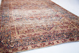 Unusual indigo cloudband border, intricate floral motifs, and historic patina of the antique Kerman rug.
