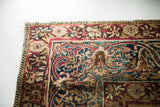 Antique Kerman rug's unusual cloudband border, ruby and indigo patterns, with outer glue line.