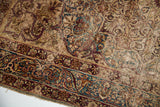 Antique Persian Kerman rug border detail, featuring unusual cloudband motif with faded indigo and heavy pile wear.