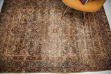 Corner of antique Kerman rug displaying unusual indigo cloudband border, worn beige field.