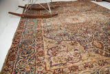 Distinctive cloudband border of the antique Persian Kerman rug, featuring faded indigo and earthy tones.