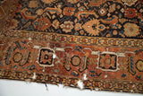 Antique Caucasian rug: rust border, walnut brown herati field, scattered moth bites.