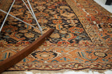 Intricate Herati pattern, aged texture, and rust border of the antique Caucasian rug.