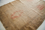 Washed-out blanched surface of an old Turkish silk rug with visible foundation wear.