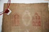 Washed-out blanched Turkish silk rug with worn red panel design and exposed foundation.