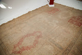 Washed-out blanched silk Turkish rug with faded red panel and hard wear.