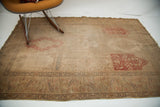 Overall view of faded Turkish silk rug, showing blanched panel designs, red accents, and extensive wear.