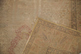 Corner of an old Turkish silk rug revealing its worn blanched pile and foundation.