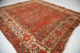 Vintage Hamadan rug corner with cranberry field, ivory Herati border, and worn fringe.