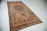 Antique Senneh Baft rug featuring a dark blue medallion and sprawling curvilinear arabesques in ivory, rust.