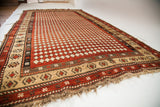 Antique Armenian rug's distinctive madder red harlequin pattern and aged texture.
