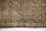 Antique Hamadan rug's blanched charcoal Herati field, subtle birds, and ivory border.