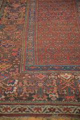 Intricate border with stylized motifs and repeating boteh on a muted red antique Kurdish rug.