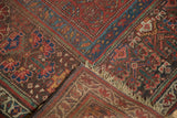 Antique Kurdish rug's folded corner, showing hand-knotted pile, edge, and woven fringe.