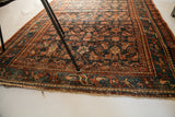 Worn edge, teal border, and dark blue Herati pattern on vintage Persian Hamadan rug.