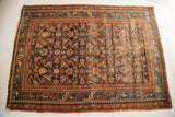 Tattered texture, Herati motif, dark blue field, and teal border on vintage Persian Hamadan rug.