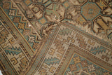 Tattered end of an antique Caucasian rug runner, displaying geometric motifs and its serrated leaf border.