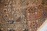 Folded antique Caucasian rug section reveals geometric patterns, hand-knotted weave, and patina.