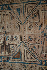 Hand-knotted tribal geometric pattern with time-softened ivory, blue, and chocolate tones.