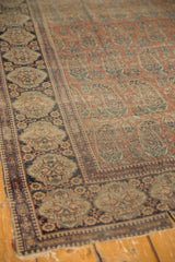 Late 19th century Mohtashem Kashan rug detail: dark blue classic border and rust paisley field.