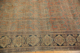 Mohtashem Kashan rug border with intricate blue and beige motifs, rust paisley field, and visible wear.