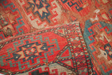 Bohemian tribal rug shows wear, holes, tatter, red, teal, and cream patterns.