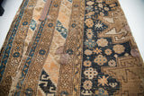 Fine weave and geometric animal motifs on the dark indigo field of an antique Caucasian rug, with visible historic repairs.