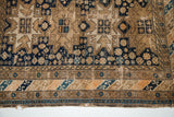 Antique Caucasian rug's geometric animal motifs and multi-band border detail.