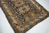 Fine weave detail and geometric indigo, tan patterns at the corner of an antique Caucasian rug.