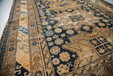 Geometric patterns and fine weave detail on the dark indigo field of an antique Caucasian rug.