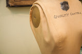 JR Bauman dress form: 'Quality Control' script on tan canvas, adjustable shoulder, slight bubbling.