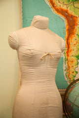 Mid century dress form, rear cotton canvas cover with slight discoloration and tied bow.