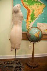 Metal base of vintage mid-century dress form with canvas body showing discoloration.