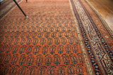 Madder red field of an antique Persian Serbend rug, showcasing boteh pattern and ornate borders.