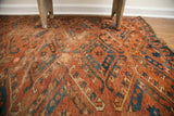 Antique Beshir rug detail showing aged brick red field, distinctive blue guls, and oversize hooks.