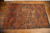 Antique Beshir rug close-up: unique hooked guls in distinct blue, deep brick red, and aged patina.