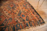Antique Beshir rug corner detail, highlighting its deep brick red and unique blue border.