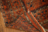 Rich, time-softened geometric patterns and soft wool pile of an antique Belouch runner.