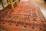 Vibrant orange and indigo geometric patterns with soft, worn wool texture on an antique Belouch runner.