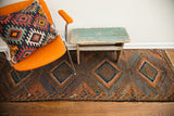 Antique Beshir runner with geometric diamond patterns, deep walnut browns, and varying blue abrash.