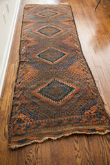 Antique Beshir runner with striking geometric diamond patterns in walnut, orange, and blue abrash.