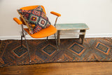 Antique Beshir runner with geometric diamonds in deep walnut, varied blues, and rust tones.