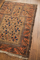Antique Belouch rug: geometric motifs on soft walnut brown field, peachy brick red border.