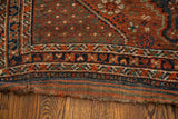 Handwoven end detail of a tribal antique Shiraz rug showing red, blue, green flatweave and tatter.