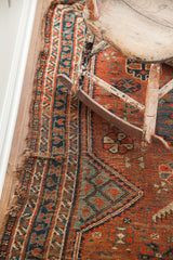 Antique Tribal Shiraz rug's detailed geometric border, time-softened red, blue, green, ivory, and visible edge wear.