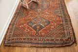 Antique Tribal Shiraz rug's worn fringe and detailed deep red, blue, ivory border.