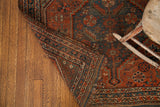 Folded edge of the antique Tribal Shiraz rug, revealing hand-knotted patterns and storied texture.