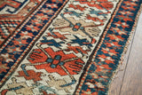 Textured border of a late 19th century Kazak rug, featuring geometric designs in red and indigo.
