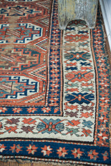 Intricate geometric patterns and alternating color borders on an antique Kazak runner.