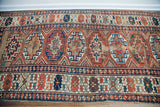 Antique Kazak runner close-up revealing geometric medallions, varied borders, and authentic wear.